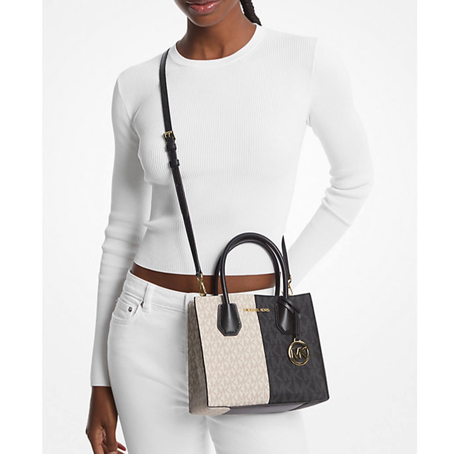 image showing beautiful girl holding Michael Kors crossbody handbag for her in black and gold color available at Heygirl.pk for delivery in Pakistan.