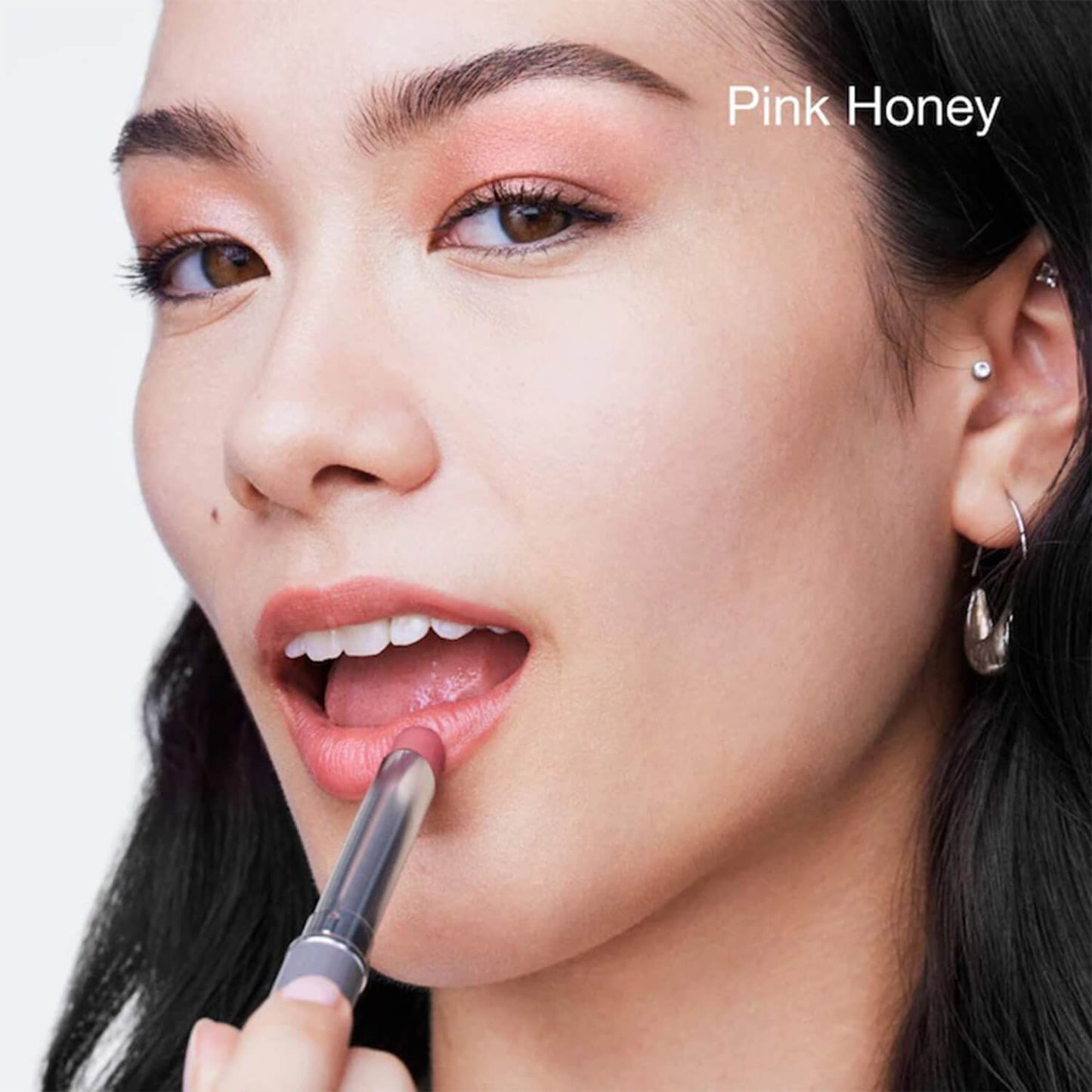 image showing happy girl using Clinique limited edition lipstick in pink honey shade for her available at Heygirl.pk for delivery in Pakistan