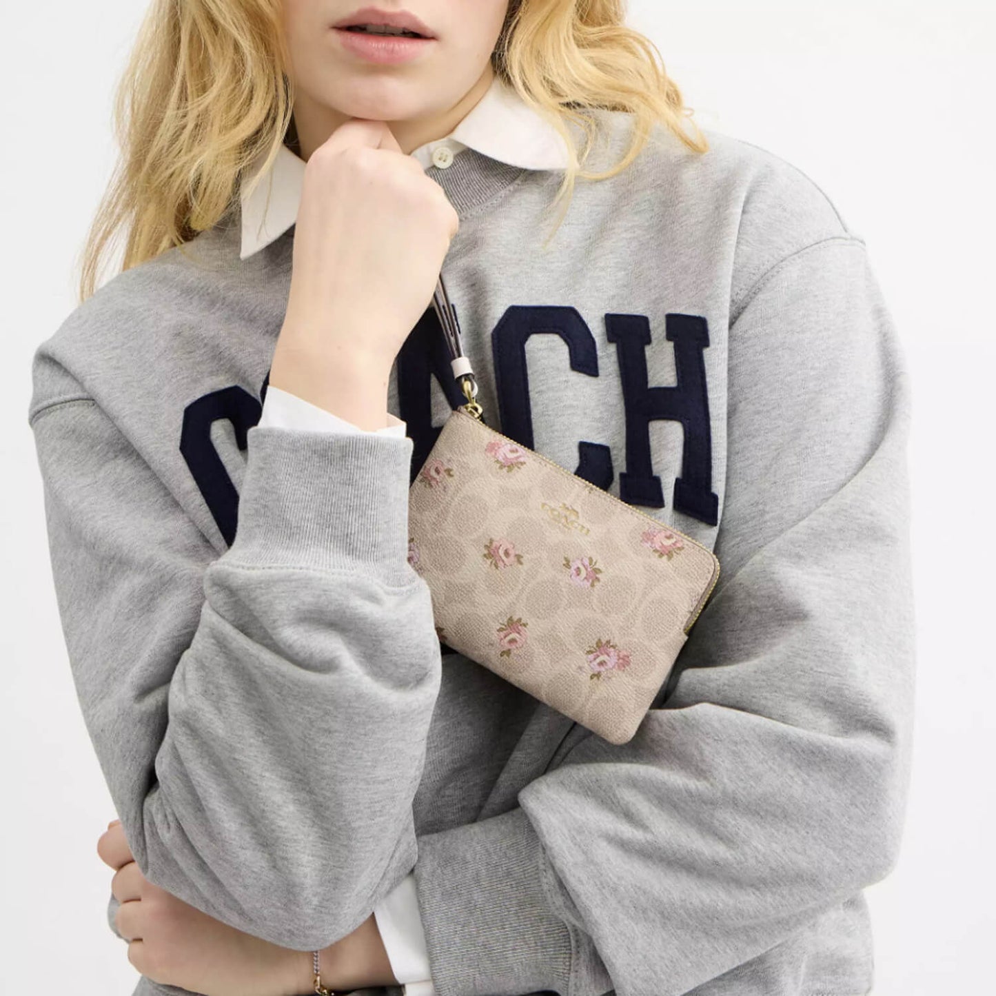 image showing girl with coach wristlet for her available at Heygirl.pk for delivery in Pakistan