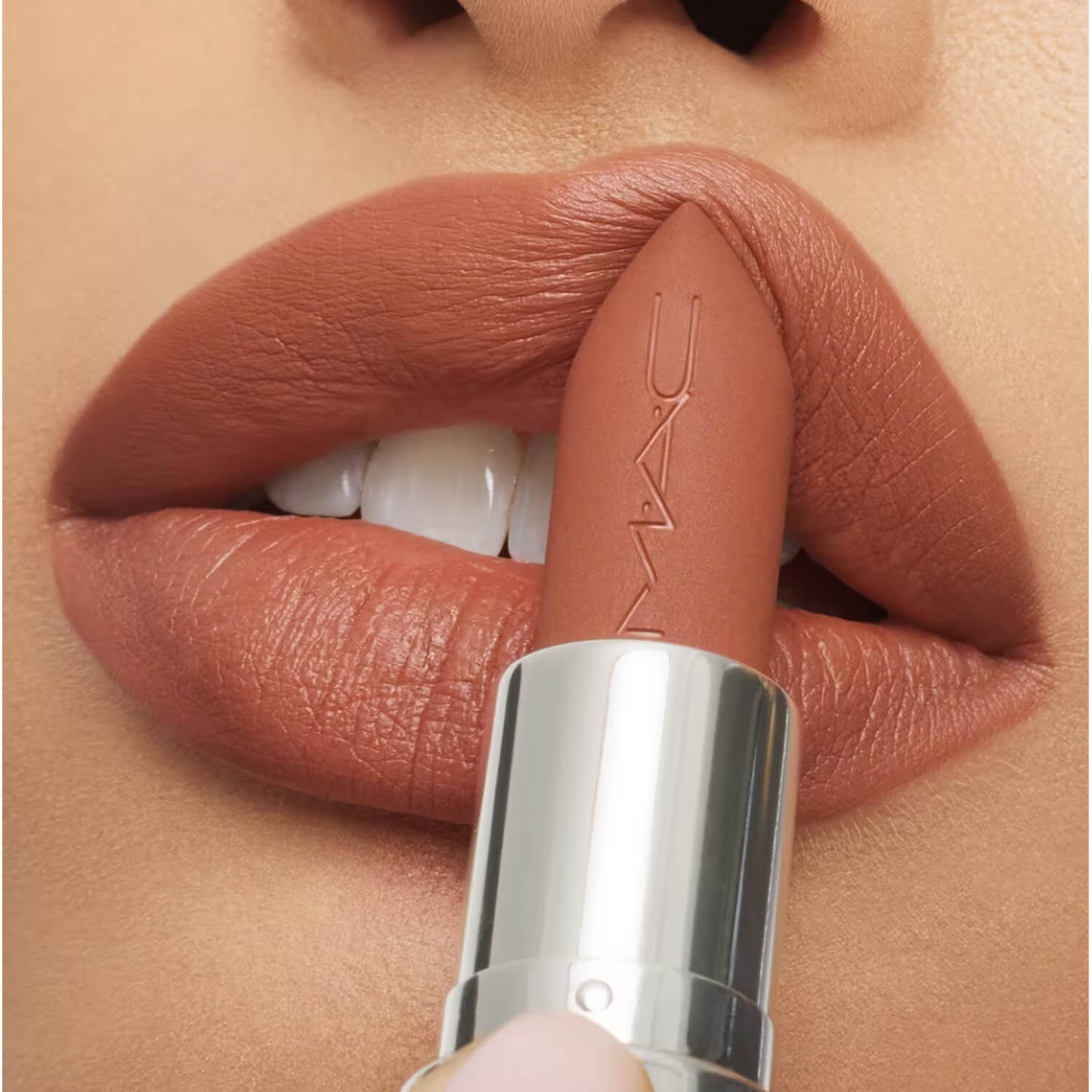 Close-up of a Pakistani girl applying a MAC nude lipstick to their lips