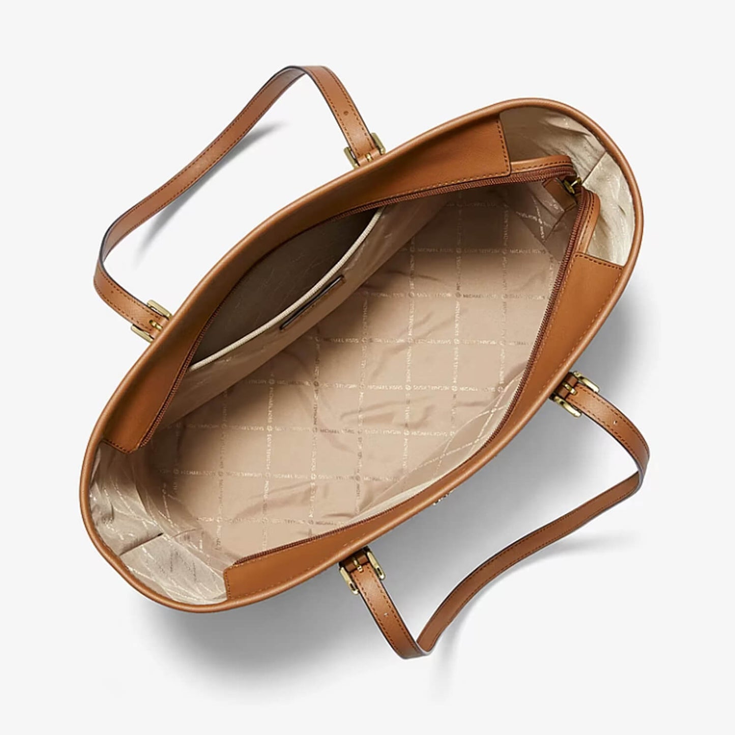 An overhead view of a Michael kors leather tote bag showing its interior lining with a beige quilted pattern and gold-tone hardware, set against a clean white background.
