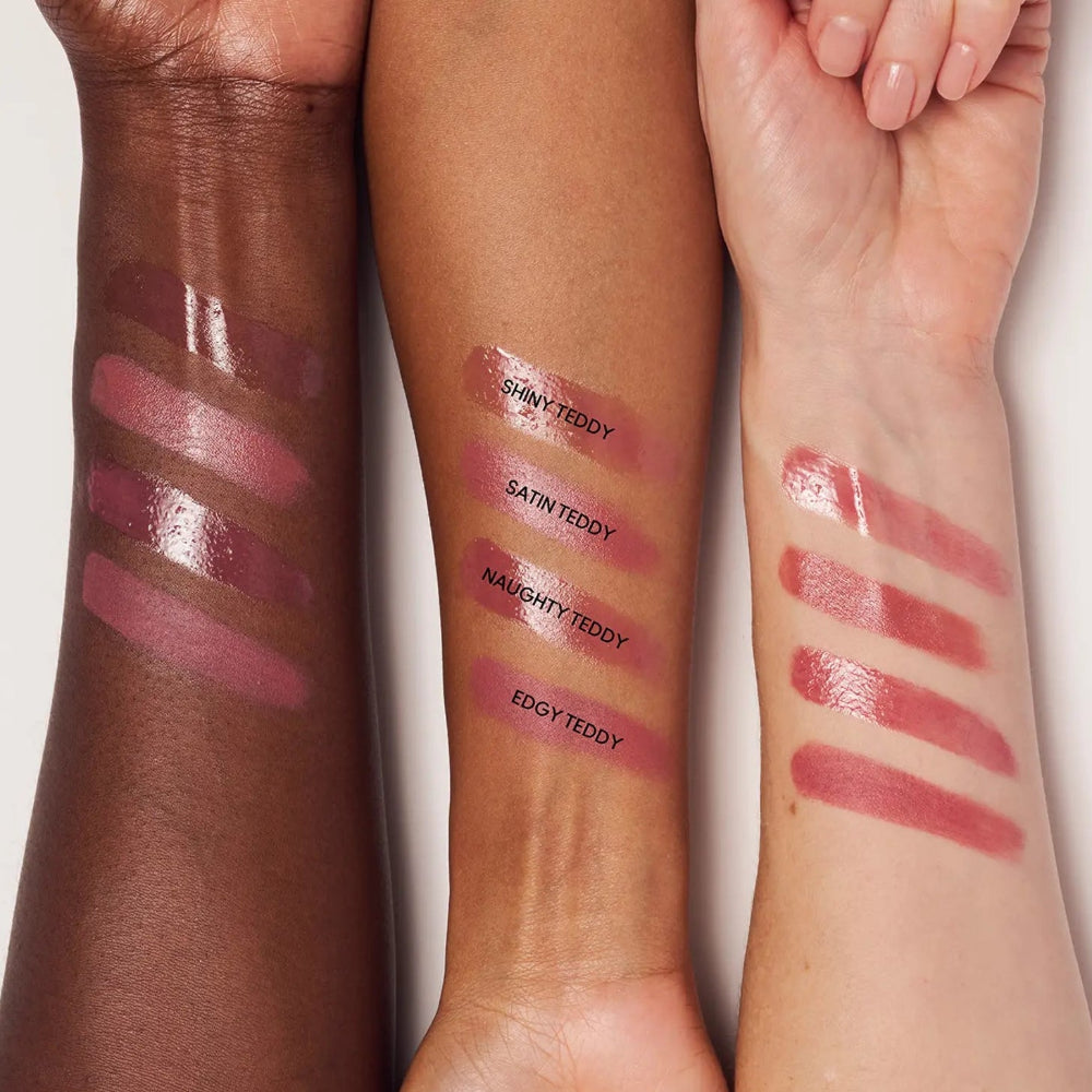 Three arms with swatches of a lip product in different shades, showing color and finish across skin tones against a light background.
