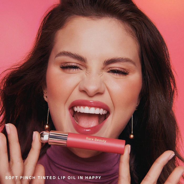image showing Selena Gomez wearing Rare Beauty Soft Pinch Tinted Lip Oil in Happy shade available at Heygirl.pk for delivery in Pakistan. 