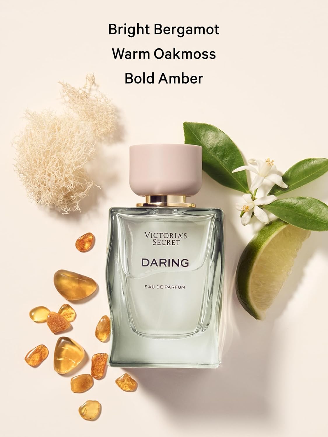 Victoria's Secret Daring perfume bottle with bergamot, oakmoss, and amber elements on a light background