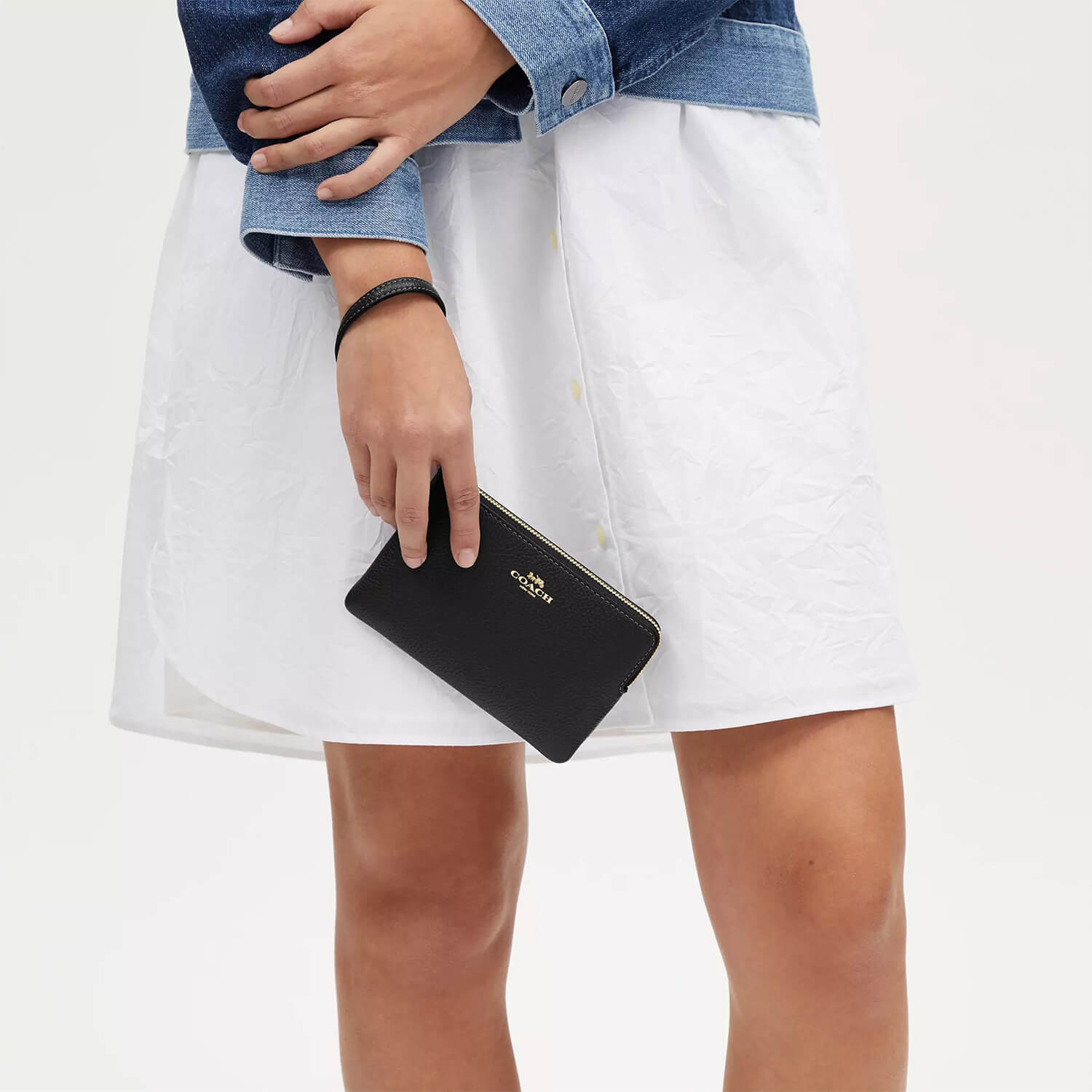 image showing girl with coach wristlet for her available at Heygirl.pk for delivery in Pakistan