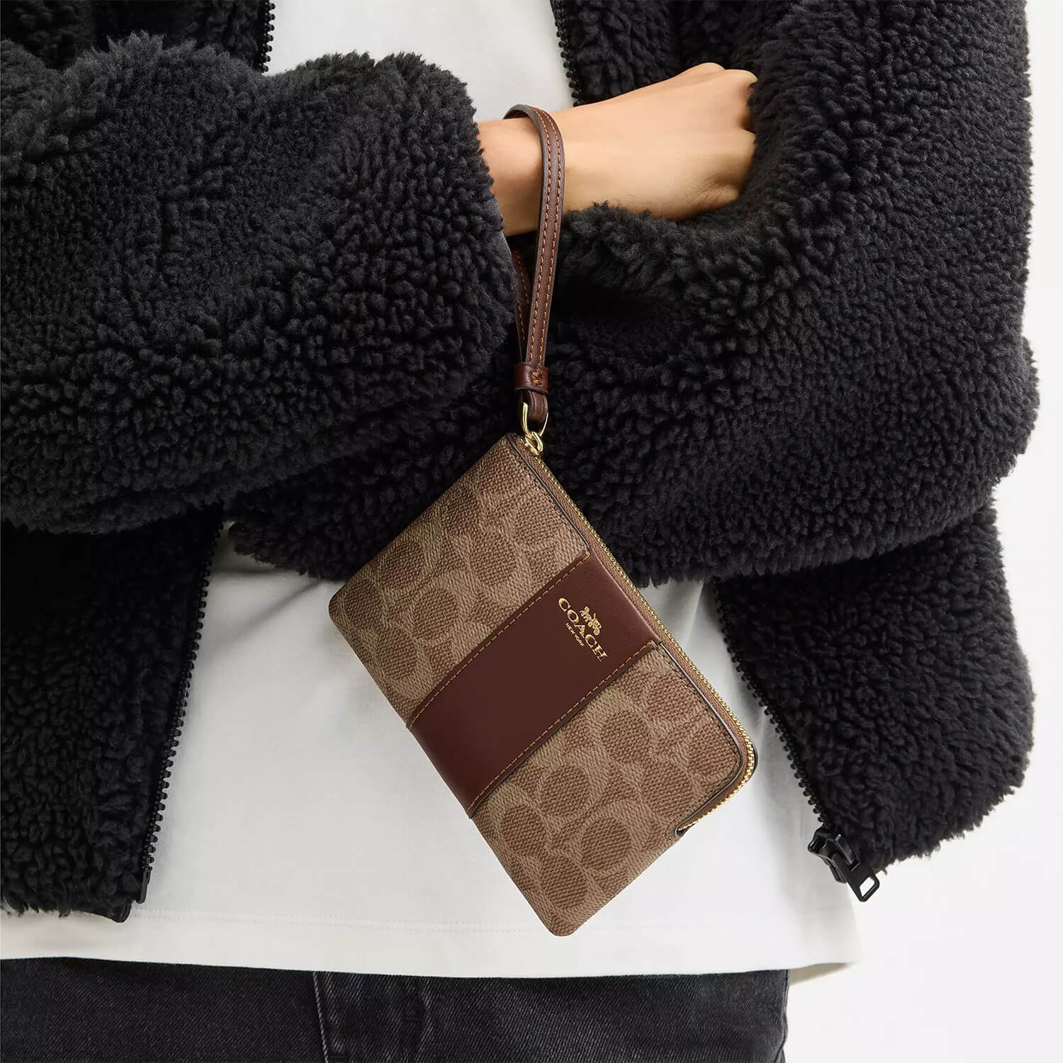 image showing girl with coach wristlet for her available at Heygirl.pk for delivery in Pakistan
