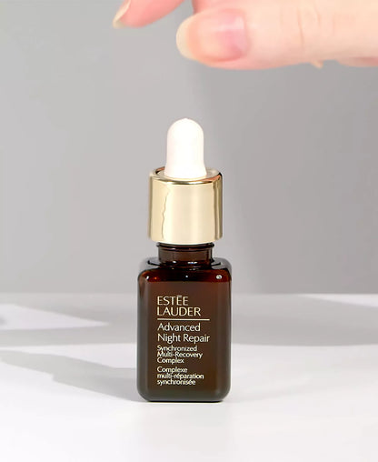 Estée Lauder Advanced Night Repair serum bottle with dropper on a gray background