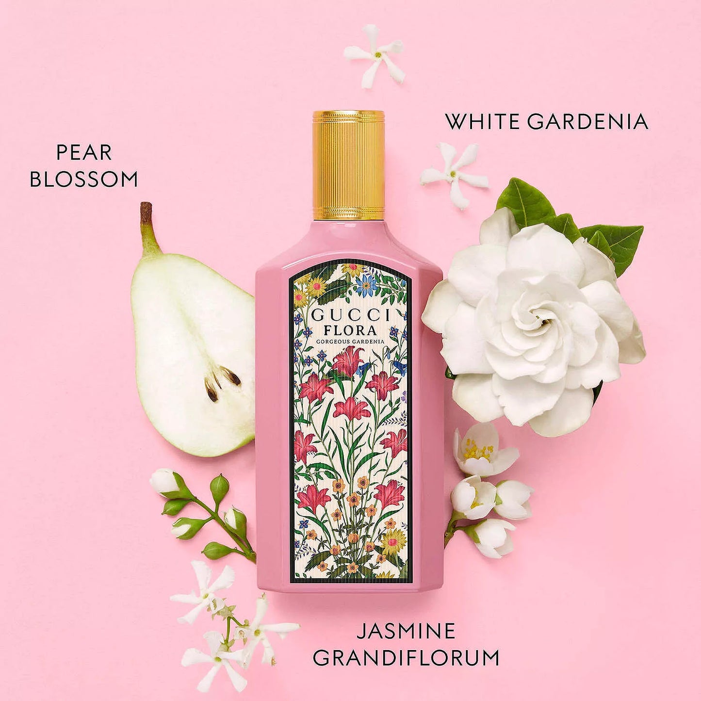 Pink bottle of Guerlain Flora with floral design, pear, and gardenia on a pink background