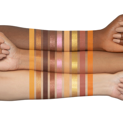 Two arms with swatches of colorful makeup products on a white background