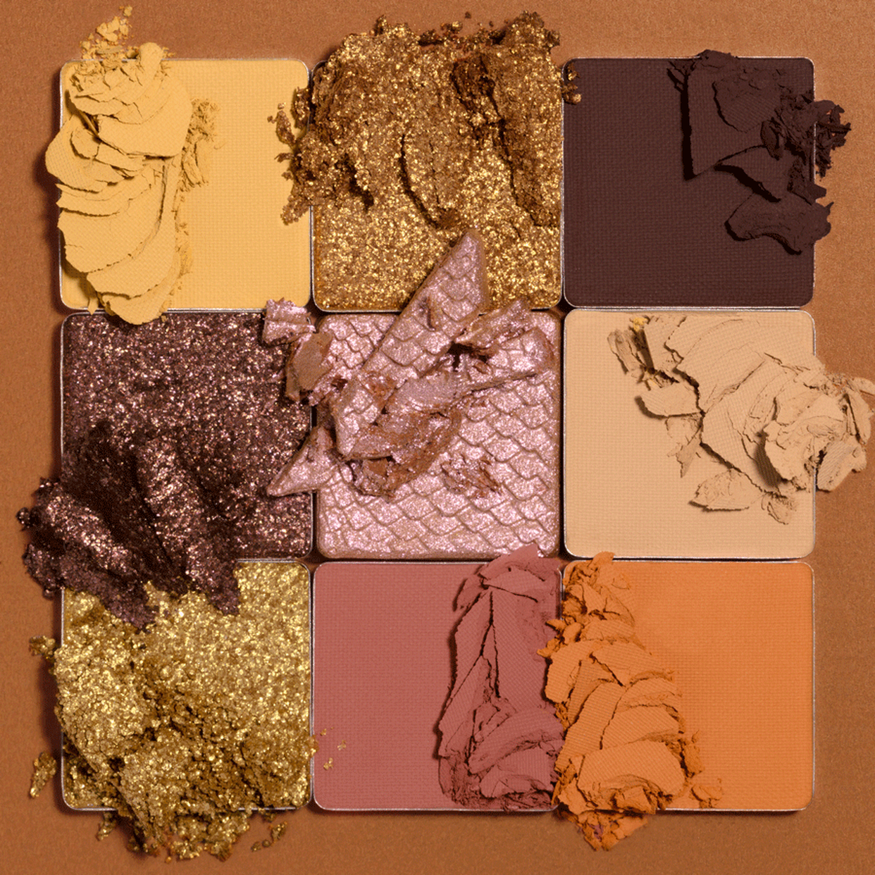 Makeup palette with various shades of eyeshadow on a brown background