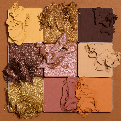 Makeup palette with various shades of eyeshadow on a brown background