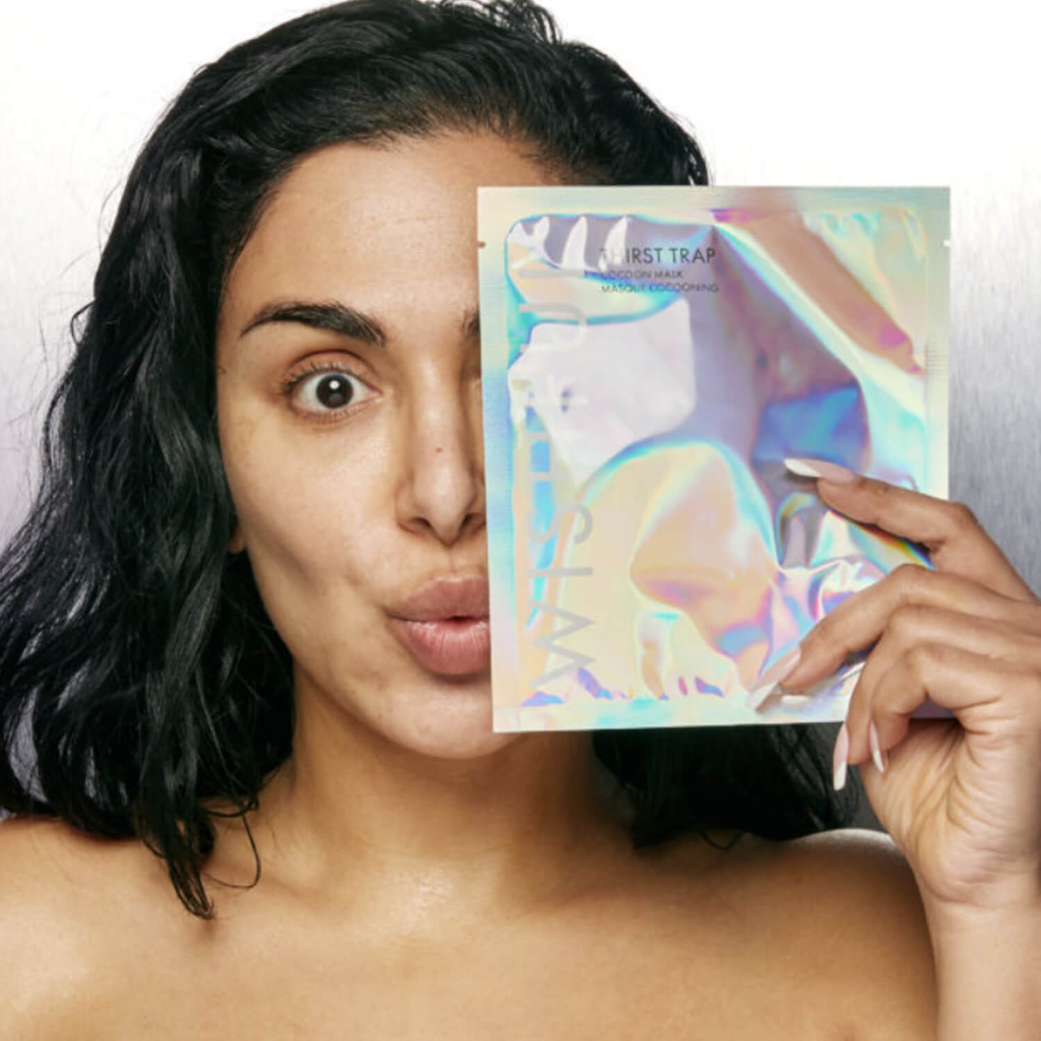 Happy girl holding ultimate quick fix solution for dehydrated skin by Huda Beauty in Pakistan