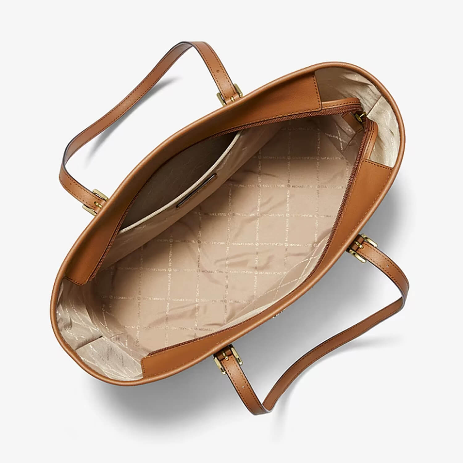 An overhead view of a Michael kors leather tote bag showing its interior lining with a beige quilted pattern and gold-tone hardware, set against a clean white background.