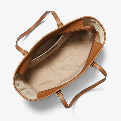An overhead view of a Michael kors leather tote bag showing its interior lining with a beige quilted pattern and gold-tone hardware, set against a clean white background.