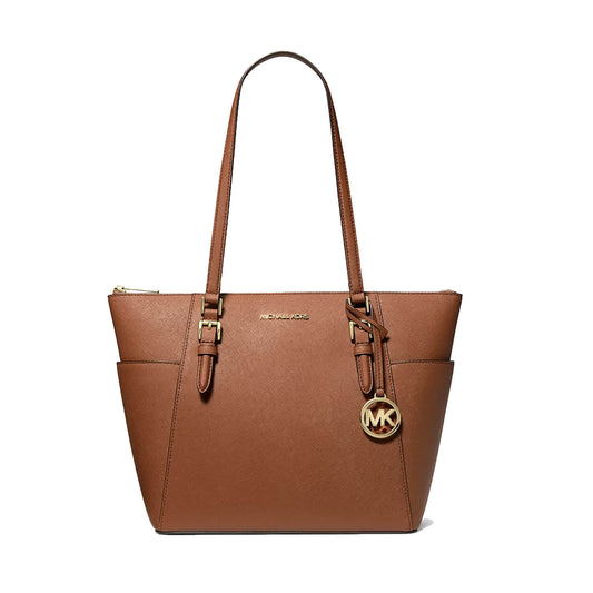 A brown leather tote bag by Michael Kors, featuring dual shoulder straps, gold-tone hardware, a front zip closure, and a hanging circular MK logo charm, shown against a plain white background.