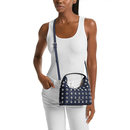A beautiful Pakistani woman holding a navy blue Michael kors handbag