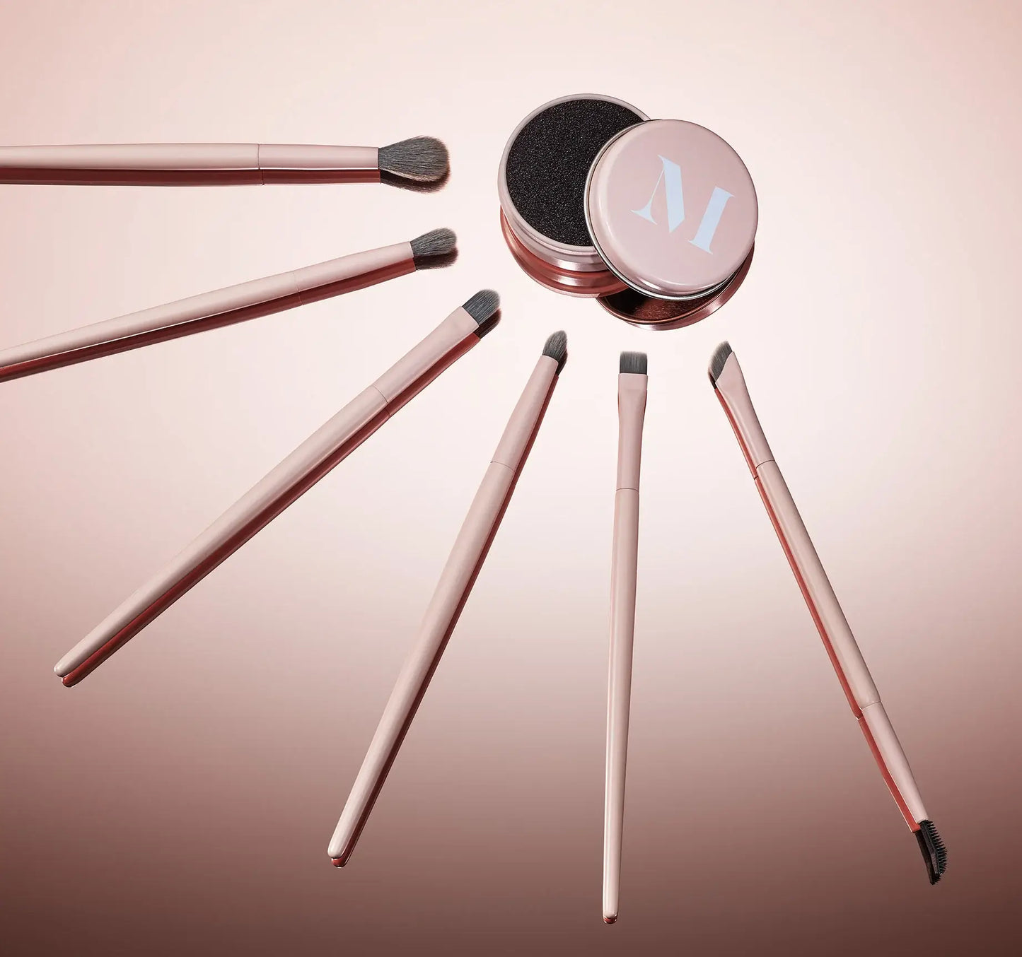 Set of makeup brushes with a pink container on a gradient background