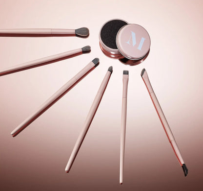 Set of makeup brushes with a pink container on a gradient background