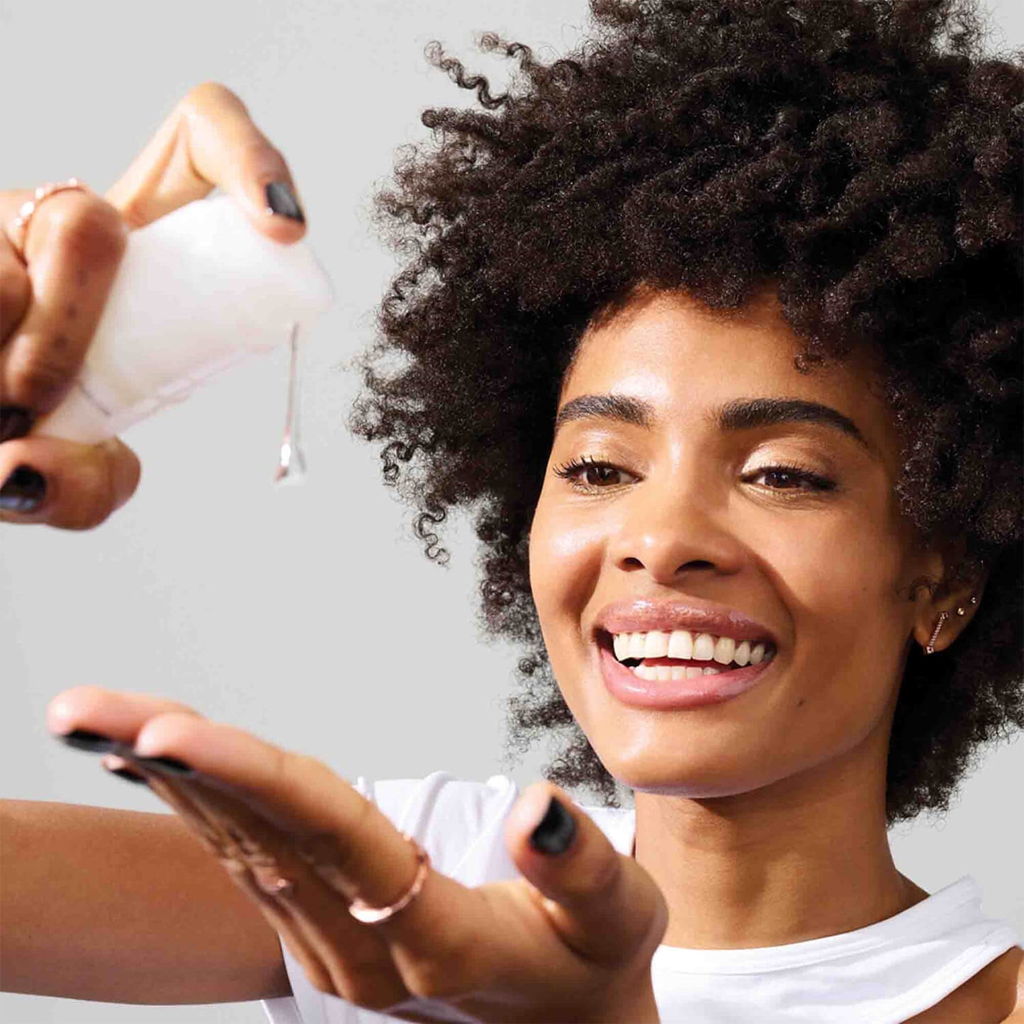 image showing happy Pakistani girl using Olaplex's best seller No 9 nourishing hair serum for damaged and dry hair available at Heygirl.pk for delivery in Pakistan. 